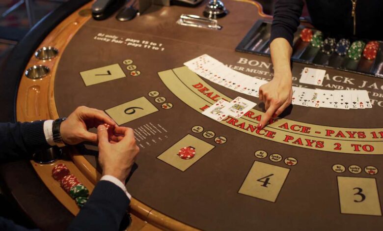 A blackjack table with cards, chips, and a dealer